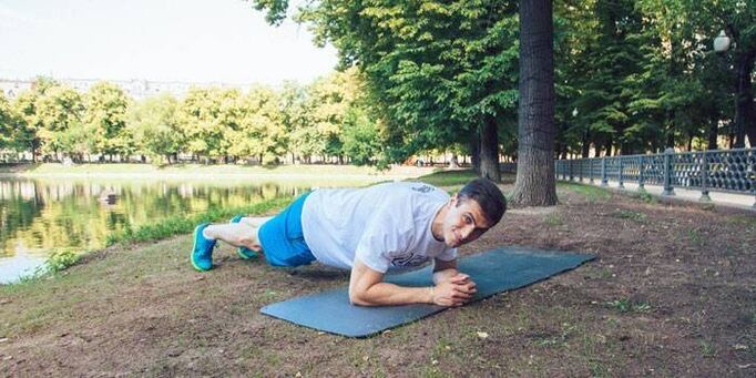 A man makes a plank to lose weight